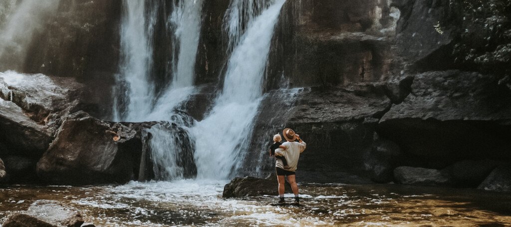 Angelika i Zoja stojące na kamieniu w wodzie przed wodospadem Cascada de la Oseguera